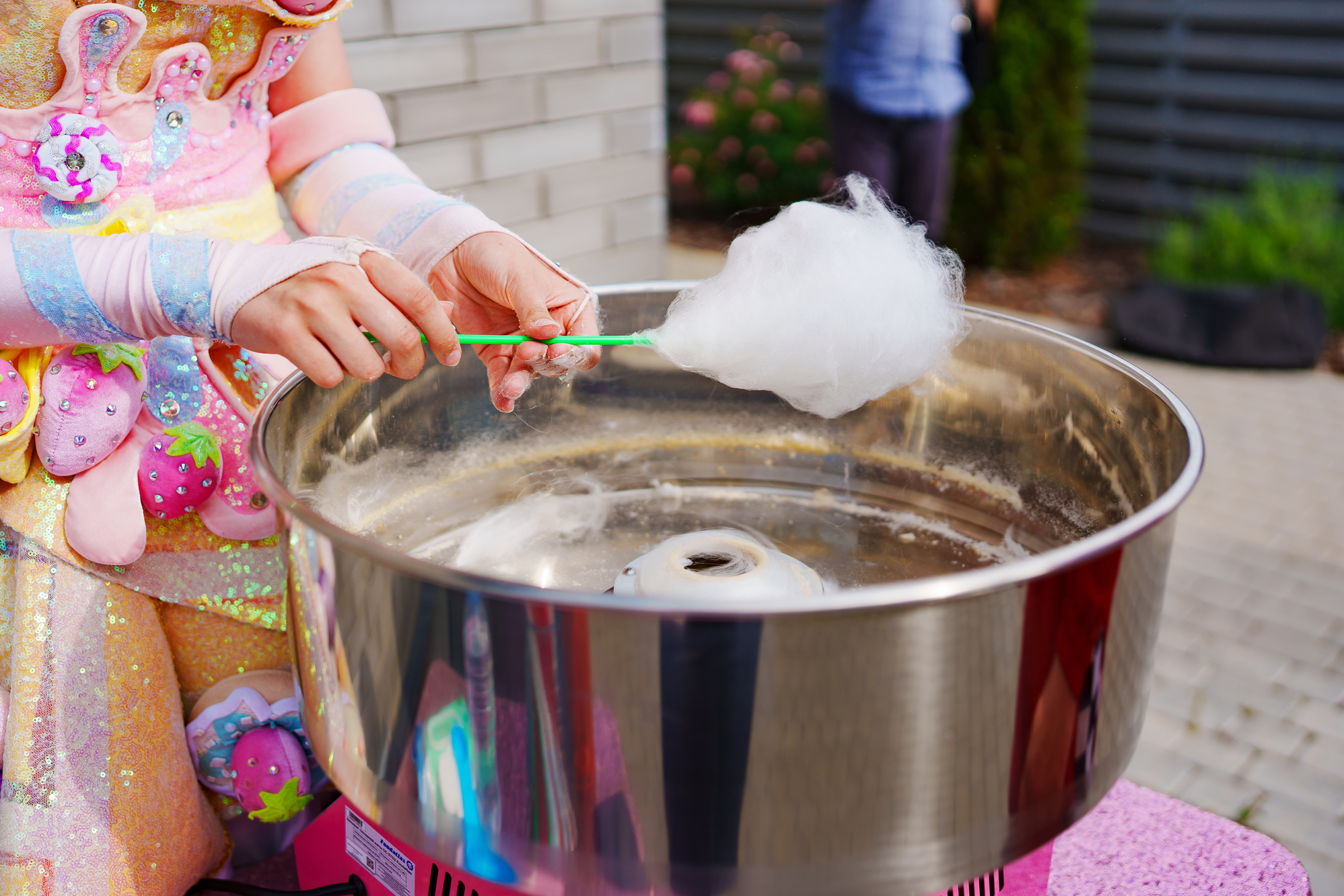 At the festival, a person deftly creates cotton candy. cotton candy machine